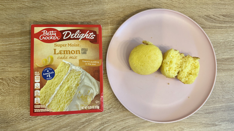 Left: a box of cake mix; right: two yellow cupcakes, one halved