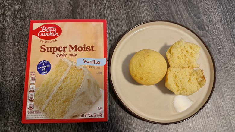 Left: a box of cake mix; right: two yellow cupcakes, one halved