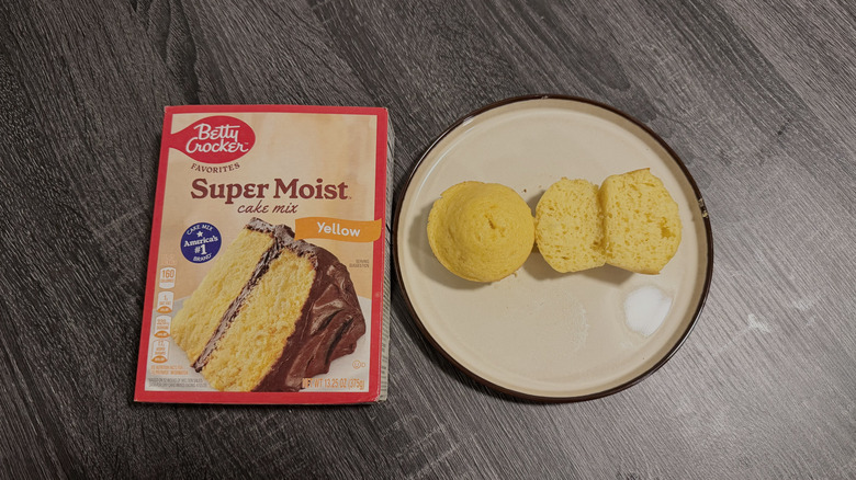 Left: a box of cake mix; right: two yellow cupcakes, one halved