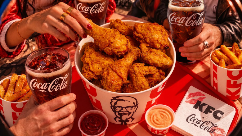 People eating KFC fried chicken and drinking Coca-Cola