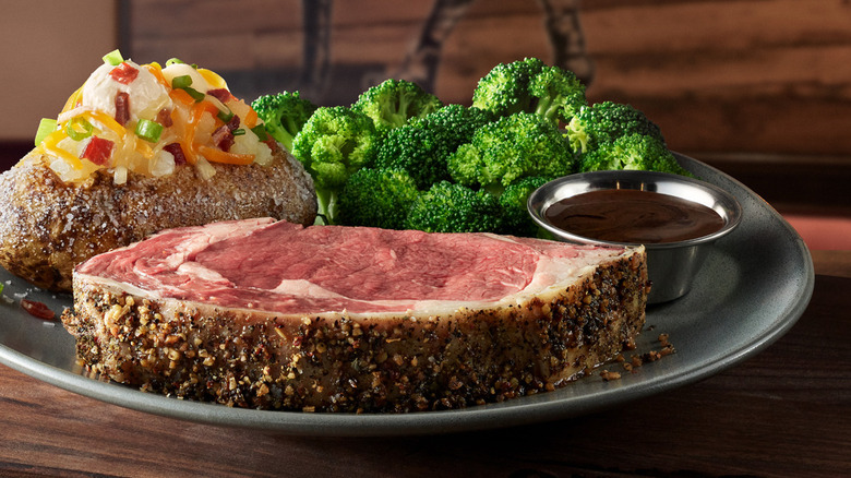 Steak with side dishes on black plate at Outback Steakhouse