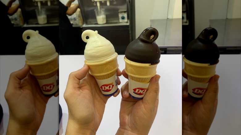 Two hands hold Dairy Queen ice cream cones in front of ice cream machine, mirrored image