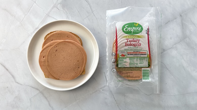 sliced bologna on bread with package of empire bologna alongside