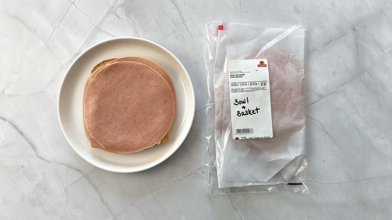 sliced bologna on bread with package of bowl and basket bologna alongside