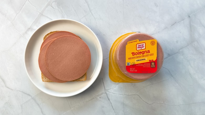 sliced bologna on bread with package of Oscar Mayer bologna alongside