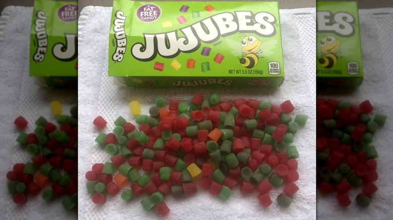 Jujubes box with candy in front on white towel, mirrored image