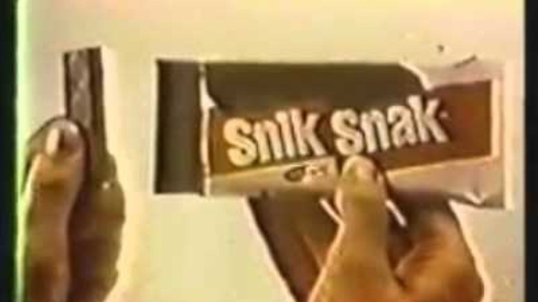 Close of still from vintage commercial, hand holding Snik Snak Stiks