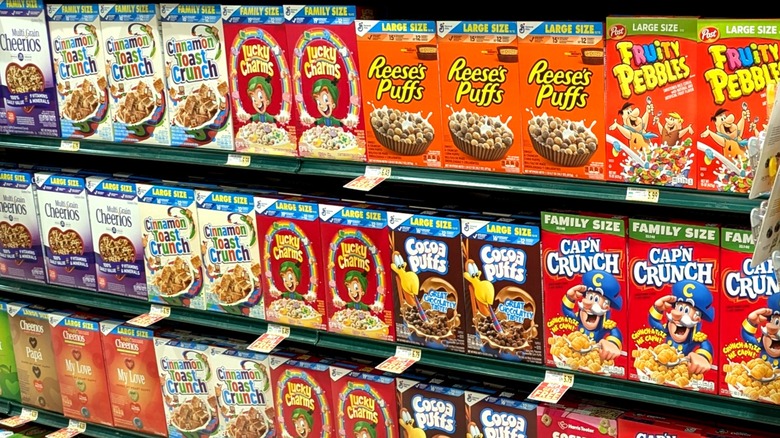 Cereal boxes on store shelves including Lucky Charms, Fruity Pebbles, and Cap'n Crunch