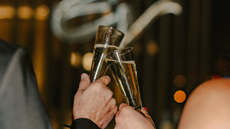Champagne being toasted with Eddie V's logo in the background