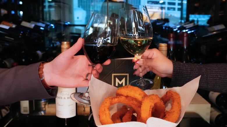 Two people toasting with Morton's logo in the background