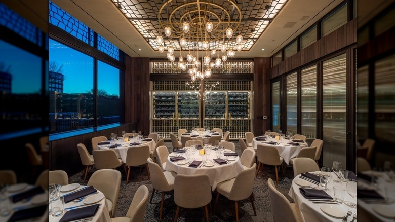 Dining room at Perry's Steakhouse with set up tables and an elegant chandelier