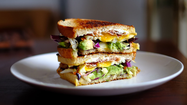 A breakfast sandwich with eggs and avocado on a plate
