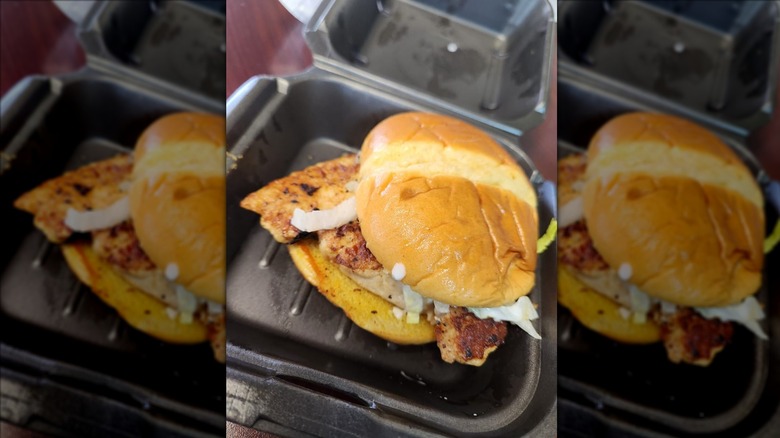 Zaxby's grilled chicken sandwich in black to-go container