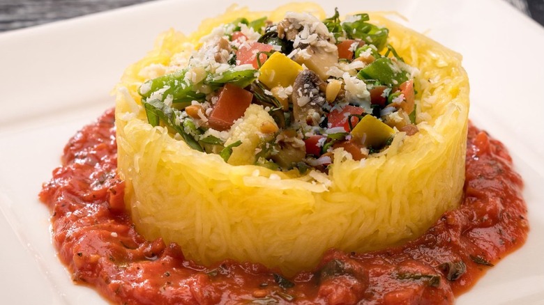 Spaghetti squash made to look like a nest, vegetables on top and sauce on bottom