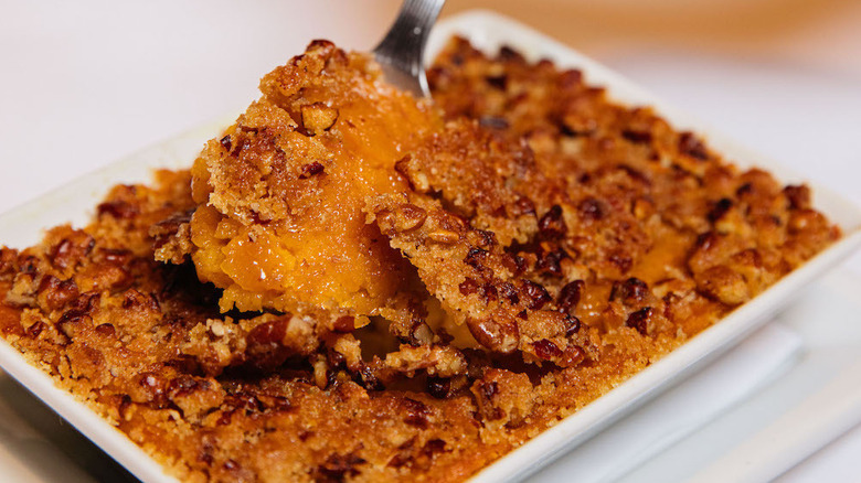 A chunk of sweet potato casserole from Ruth's Chris being scooped up with a fork