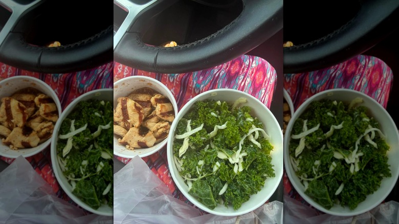 Chick-fil-A chicken nuggets and kale crunch salad on person's lap in car