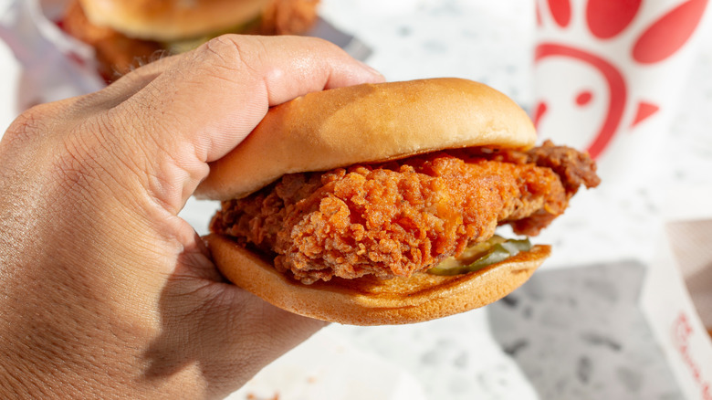 Hand holding a Chick-fil-A chicken sandwich