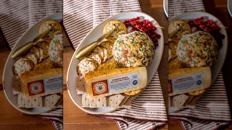Wedge of Sartori Tomato Basil BellaVitano on cheese plate with crackers