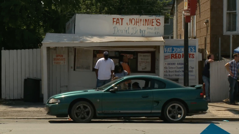 The Fat Johnnie's hot dog stand with a green car parked outside