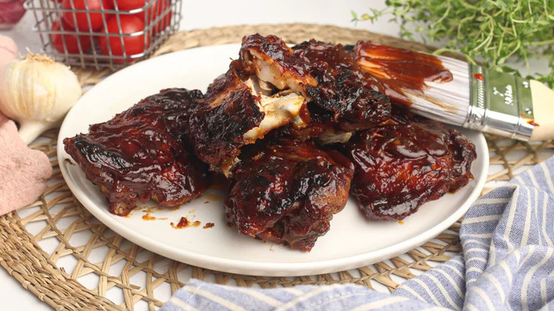 Oven Baked BBQ Chicken on white plate with sauce brush
