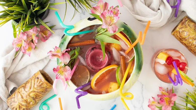 Aerial view of over-the-top Scorpion punch bowl with colorful straws, sliced fruit and hibiscus flowers.