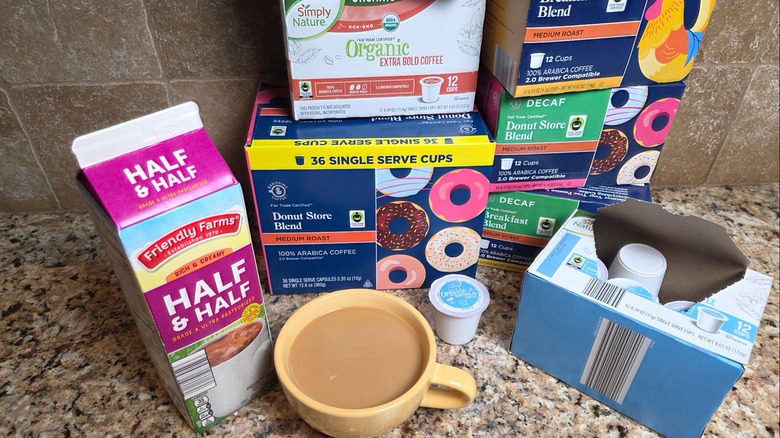 Half and half carton, coffee in a yellow coffee cup, coffee pod boxes, and coffee pods