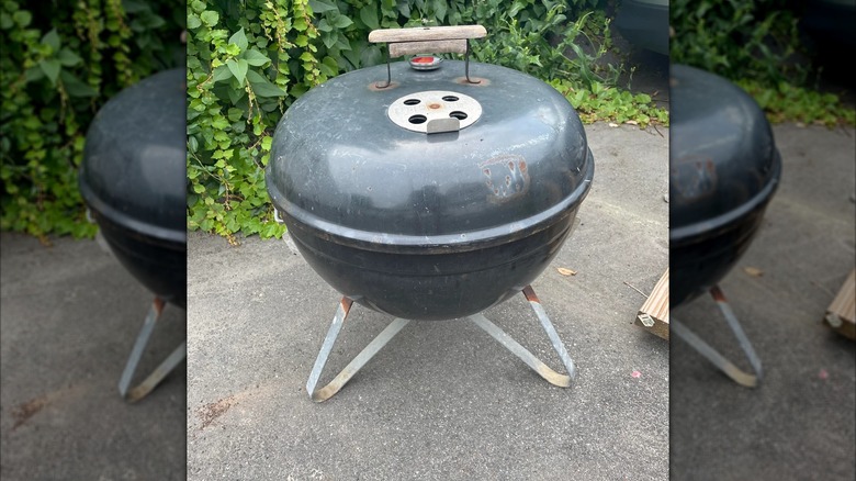 Rusty Weber grill on asphalt
