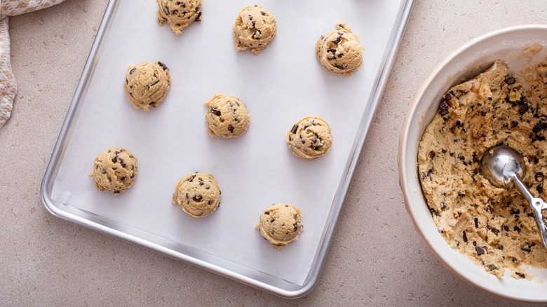 Uncooked scoops of cookie dough on baking tray