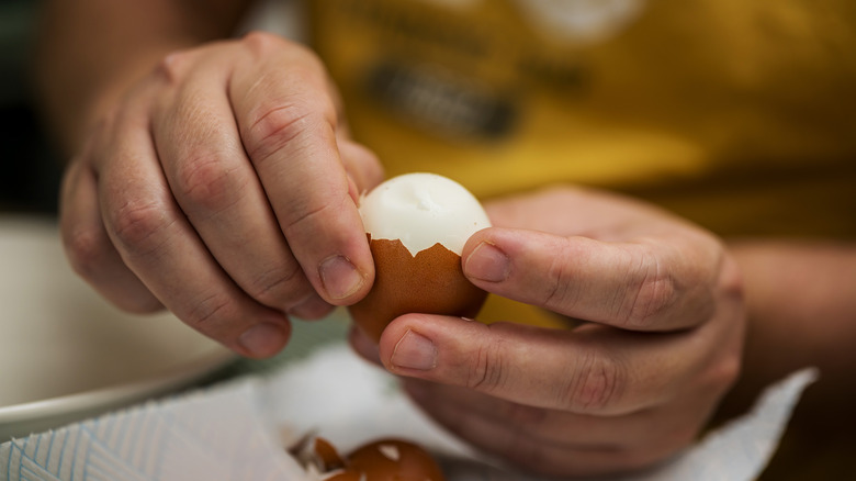 Person peeling boiled eggs