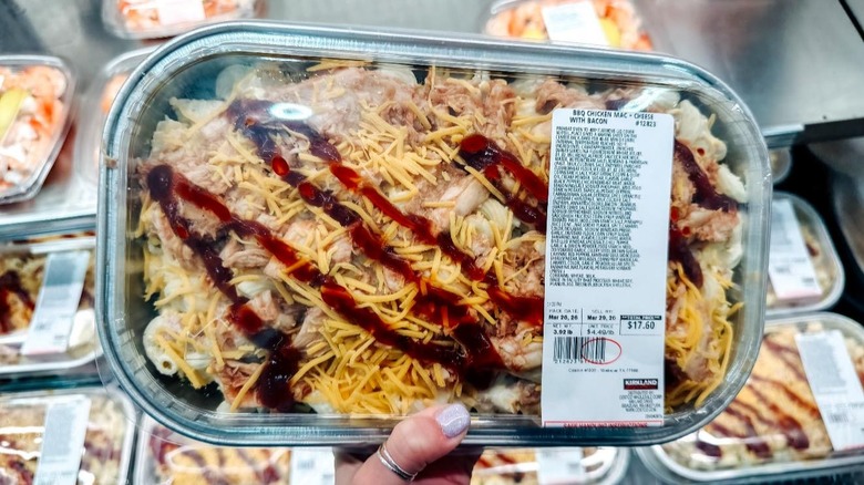 Hand holding tray of Costco Kirkland Signature BBQ Mac and Cheese