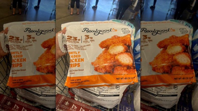 Hand holding bag of Realgood Foods Lightly Breaded Chicken Strips