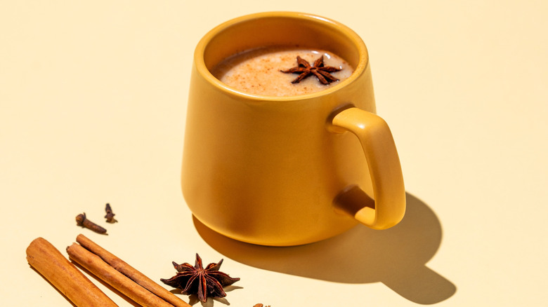 chai latte in yellow mug on pale yellow background