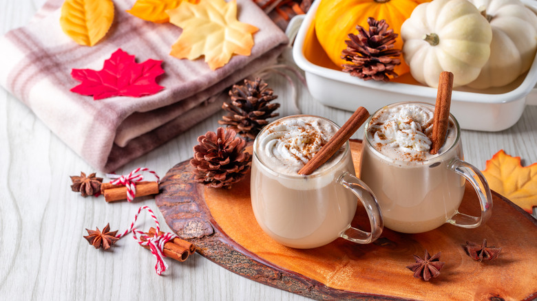 lattes in clear mugs with pinecones, leaves, and pumplins