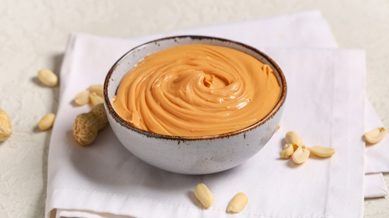 Bowl of tasty peanut butter with nuts