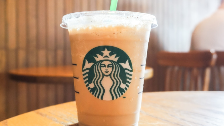 A grande vanilla sweet cream drink on a wooden table