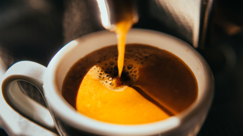 Coffee machine pouring out espresso, close-up.