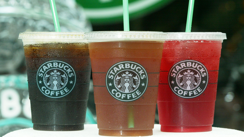 Three cold Starbucks drinks with no ice inside of the cups