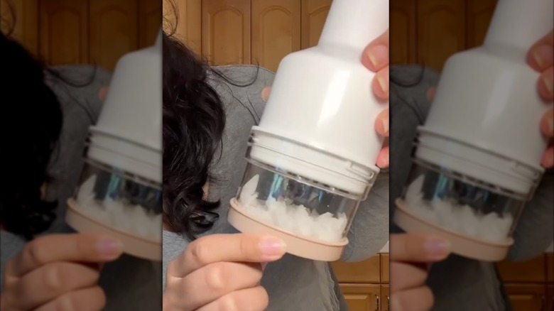 Person holding vegetable chopper with onions