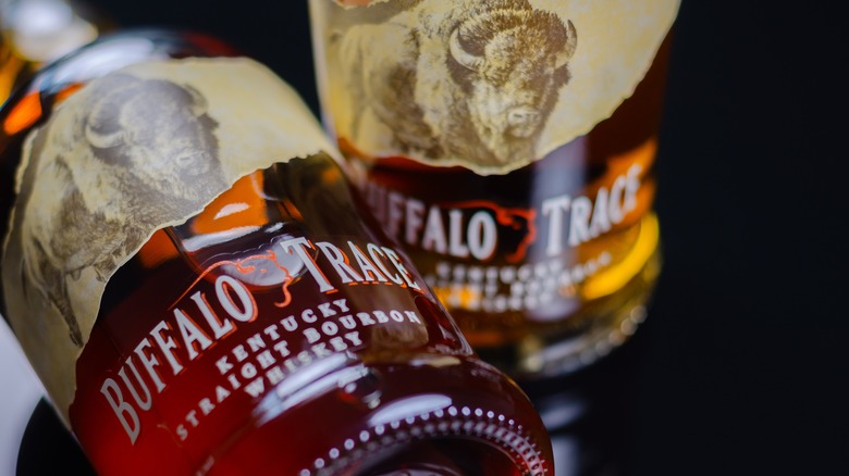 Two bottles of Buffalo Trace whiskey, one placed upright, one on its side