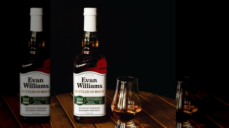 A glass of Evan Williams Bottled-In-Bond whiskey next to the bottle