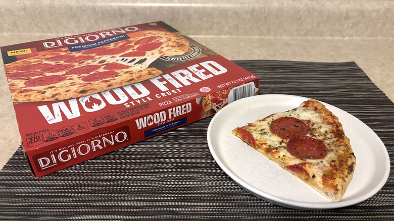 DiGiorno wood fired crust style pizza in box and slice on plate on black placemat