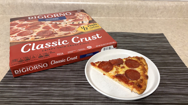 DiGiorno classic crust style pizza in box and slice on plate on black placemat