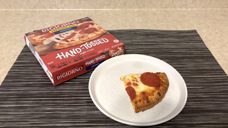 DiGiorno hand-tossed crust style pizza in box and slice on plate on black placemat