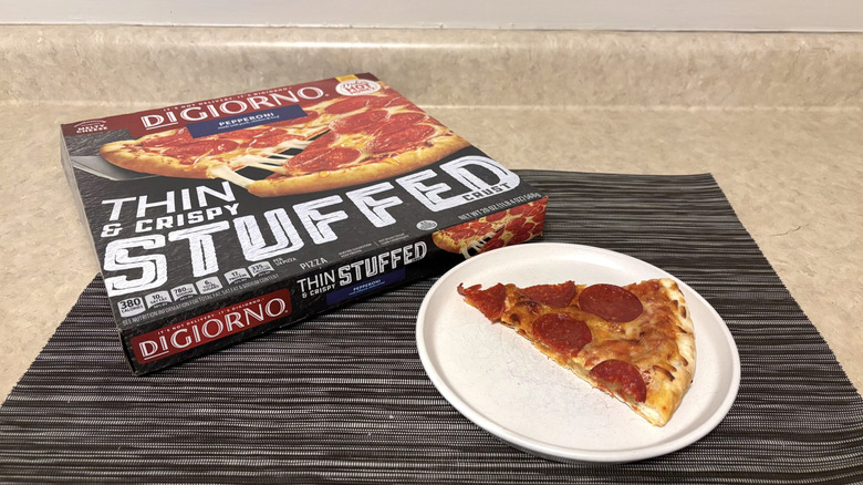 DiGiorno thin & crispy stuffed crust style pizza in box and slice on plate on black placemat