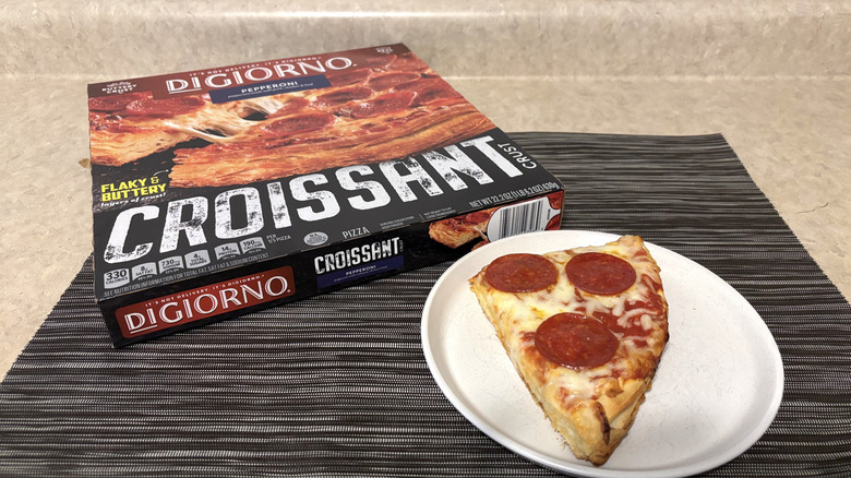 DiGiorno croissant crust style pizza in box and slice on plate on black placemat