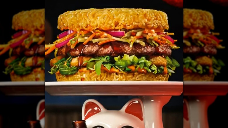 Ramen burger on plate held by ceramic lucky cat figure