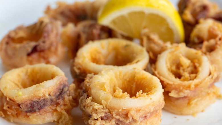 calamari rings coated in seasoned batter with slice of lemon