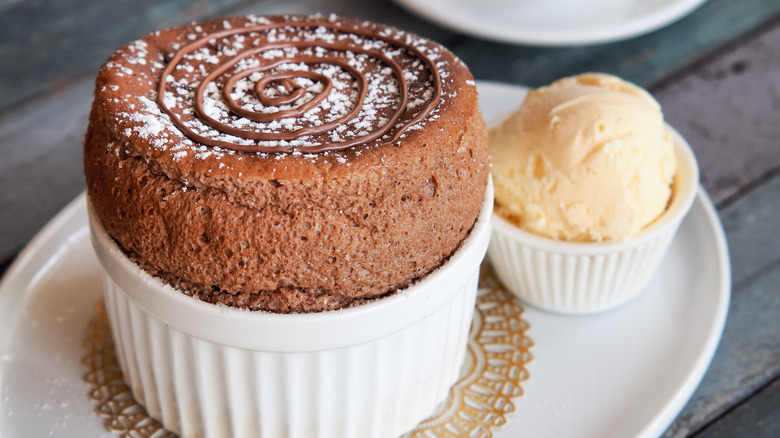 Chocolate souffle in a ramekin with vanilla ice cream on he side