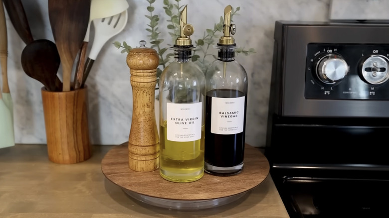Small Lazy Susan turntable in kitchen holding olive oil and vinegar dispensers and pepper mill
