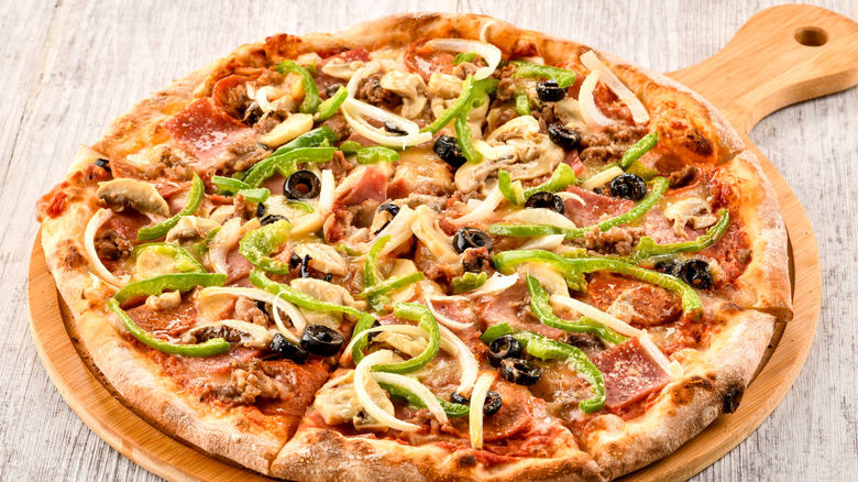 combo pizza on wooden pizza board